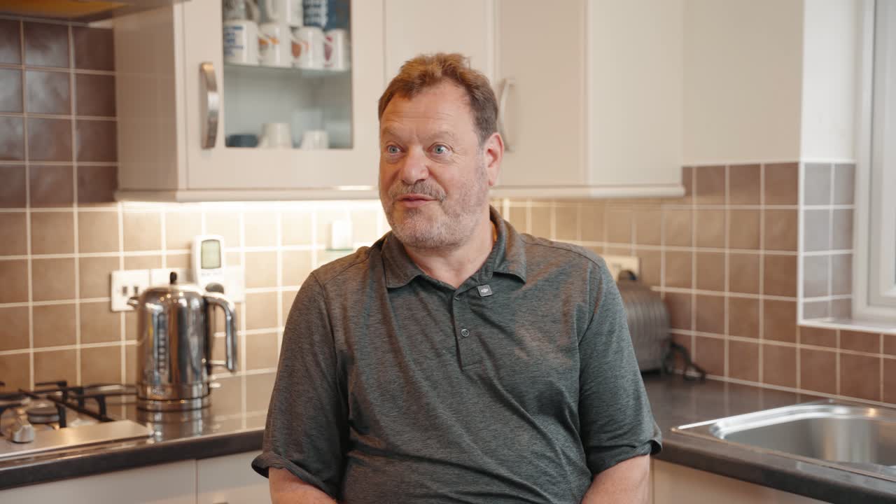 Male customer giving a video testimonial about Southern Softflow in his kitchen